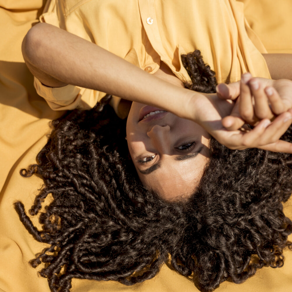 young-woman-lying-yellow-cloth-nature